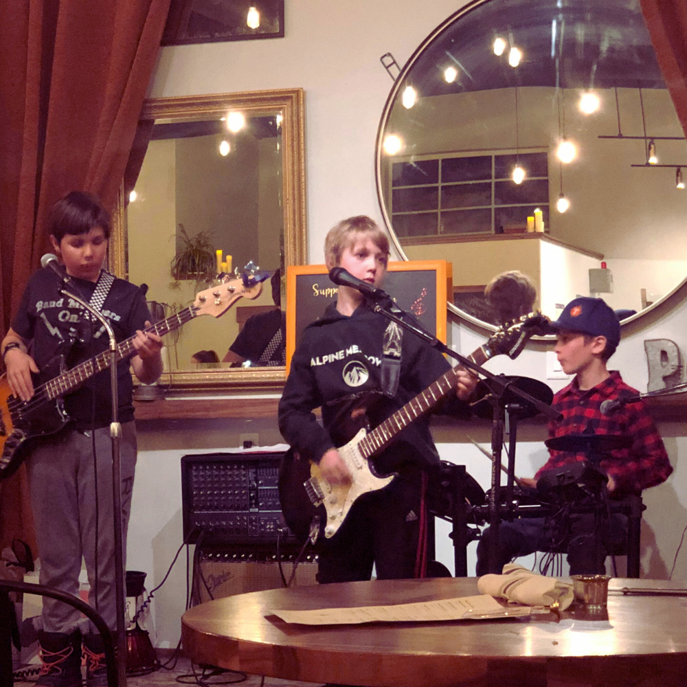 Young rock band performing at intimate venue with full band setup
