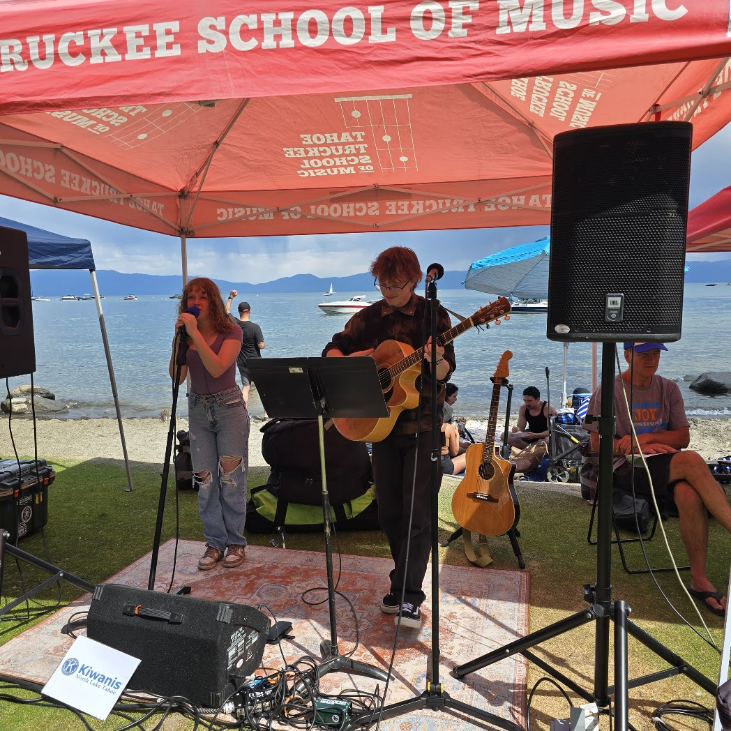 Young musicians performing under TTSM tent at lakeside event