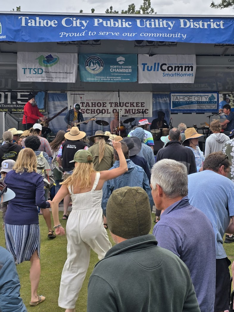 Large crowd dancing at Tahoe City summer concert series with TTSM on stage