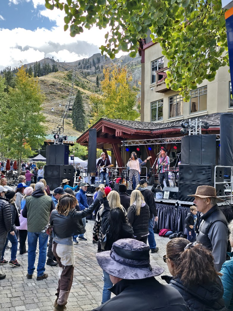 Band performing on stage at Made in Tahoe festival at Palisades with mountains behind