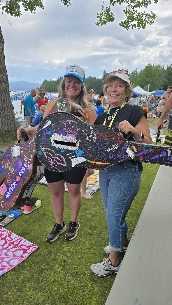 Volunteers holding signed guitar case at Tahoe Joy Festival