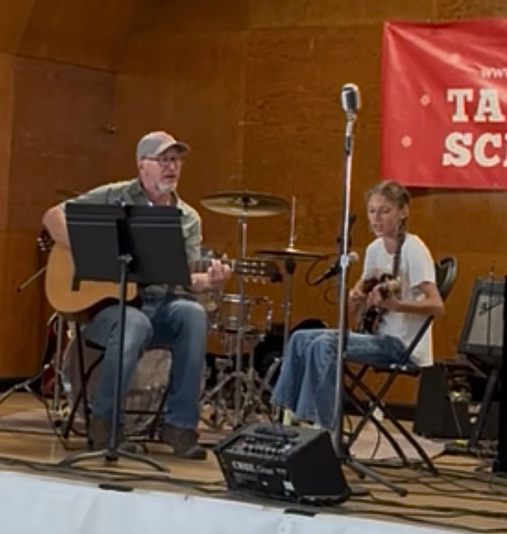 Older musician and young student performing together on stage at TTSM recital