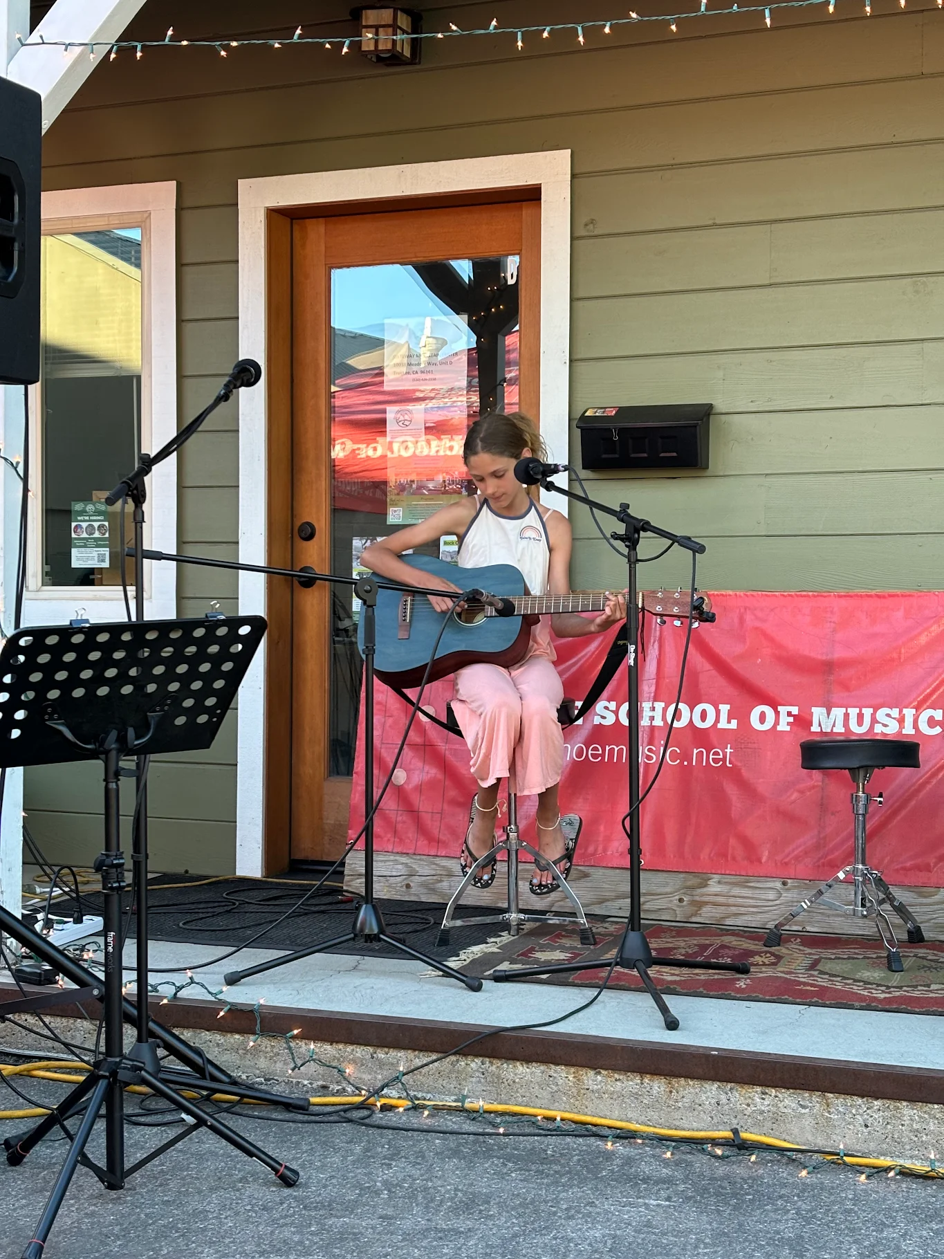 Young girl performing guitar solo outside TTSM studio at open mic