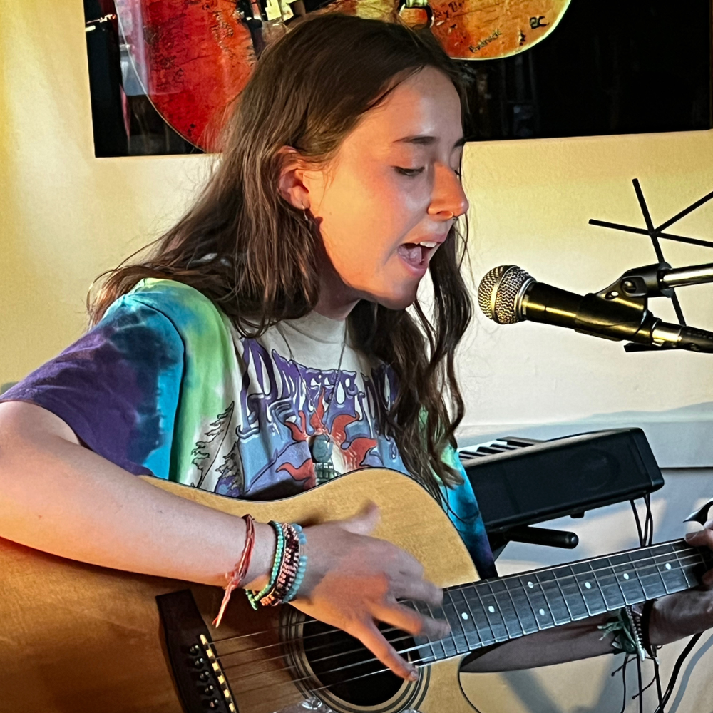 Young musician developing skills singing and playing acoustic guitar