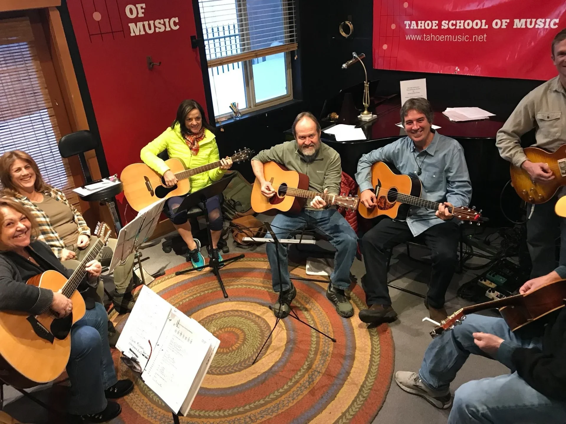 Musicians playing guitars together at Song Group in the TTSM studio